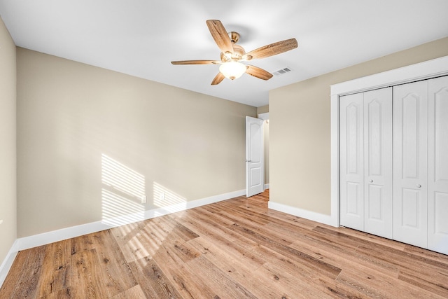 unfurnished bedroom featuring ceiling fan, light wood-type flooring, and a closet