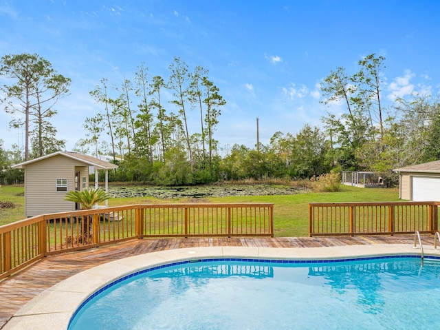 view of swimming pool featuring an outbuilding, a yard, and a wooden deck