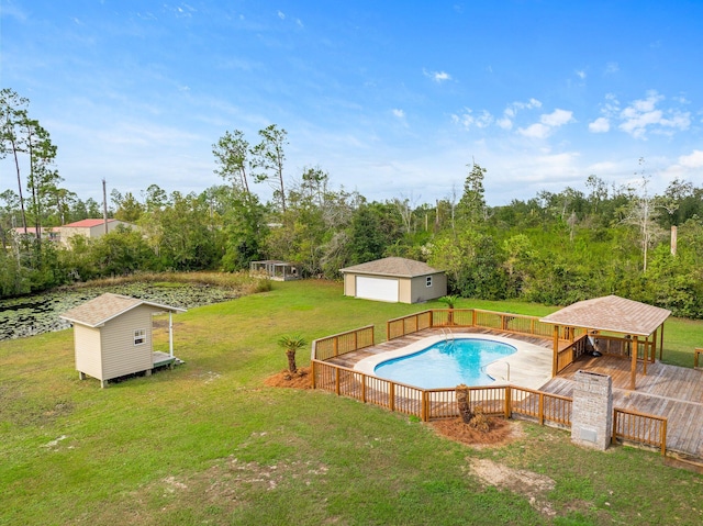 view of swimming pool with a lawn, a storage unit, a garage, and a deck