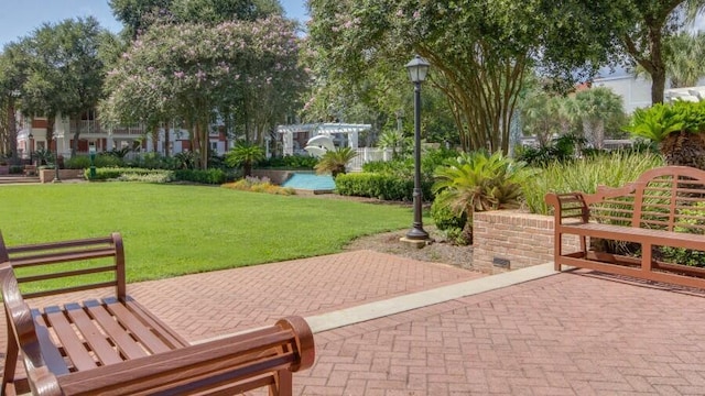 view of community with a lawn and a patio