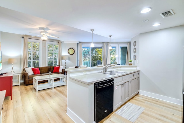 kitchen with sink, hanging light fixtures, ceiling fan, light wood-type flooring, and kitchen peninsula