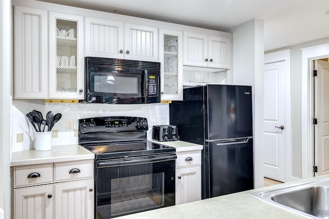 kitchen with backsplash, white cabinetry, and black appliances