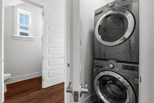 82 Gulfview Way, Santa Rosa Beach, FL 32459 - washroom featuring stacked washer and clothes dryer, dark wood-style floors, and baseboards