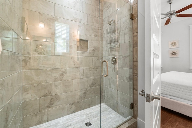 bathroom with hardwood / wood-style flooring, ceiling fan, and an enclosed shower