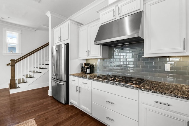 kitchen featuring appliances with stainless steel finishes, dark hardwood / wood-style floors, white cabinetry, and dark stone counters