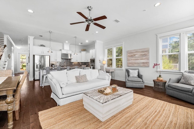 living room with ceiling fan, crown molding, dark wood-type flooring, and a wealth of natural light