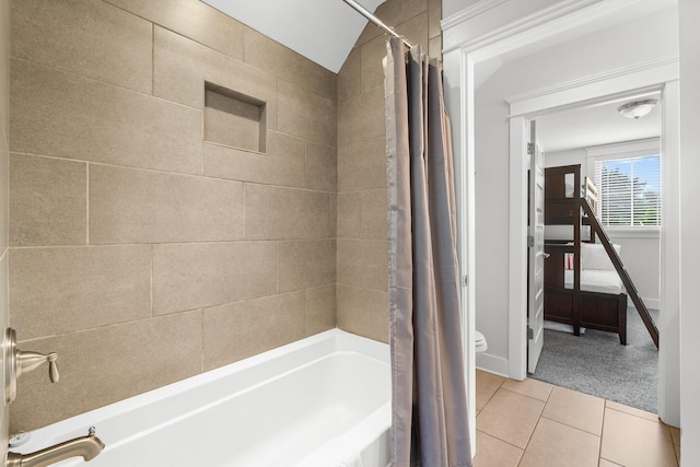 bathroom featuring tile patterned flooring, shower / bath combination with curtain, toilet, and lofted ceiling