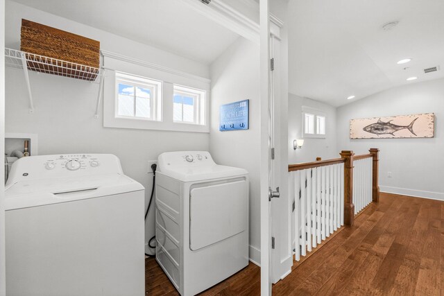 laundry room with washing machine and clothes dryer and dark hardwood / wood-style floors