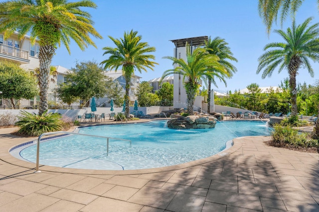 view of swimming pool with pool water feature and a patio area