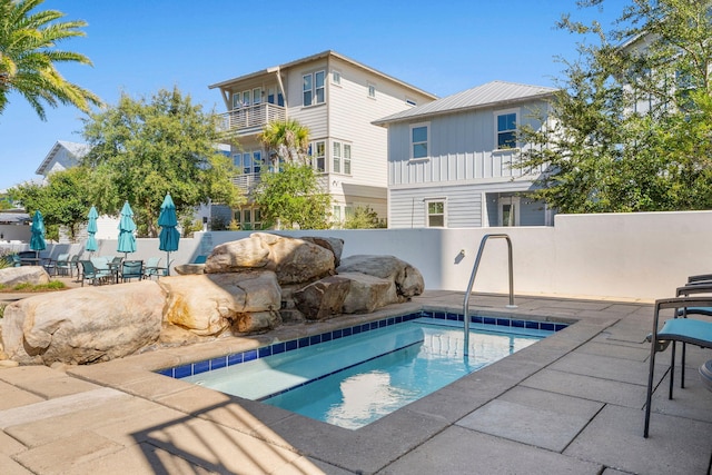 view of swimming pool featuring a patio and a hot tub