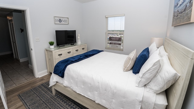 bedroom featuring a walk in closet and dark hardwood / wood-style floors