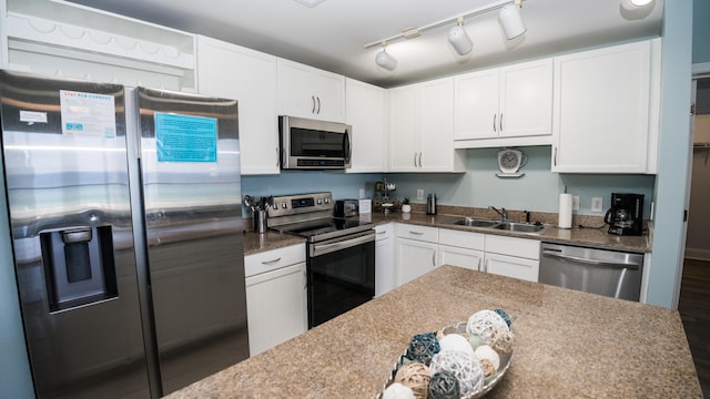 kitchen with stainless steel appliances, white cabinetry, dark wood-type flooring, and sink