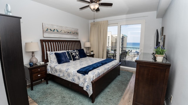 bedroom with hardwood / wood-style floors, access to outside, and ceiling fan