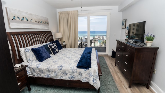 bedroom with access to exterior and light hardwood / wood-style floors