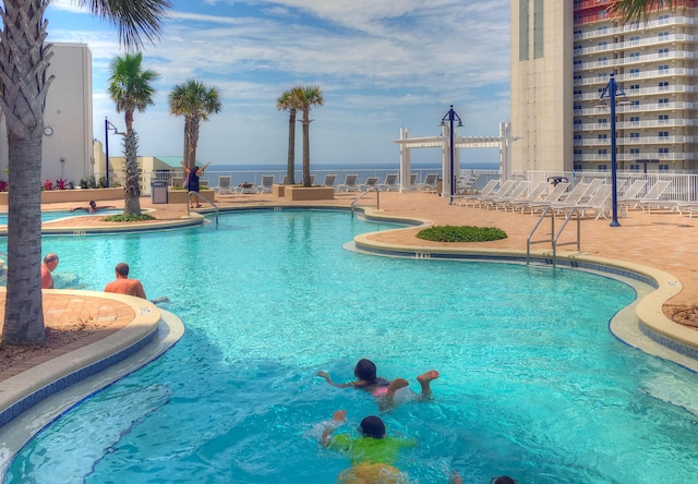 view of pool with a patio area and a water view