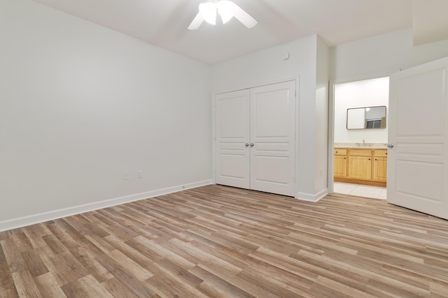 unfurnished bedroom featuring baseboards, a ceiling fan, a closet, and light wood-type flooring