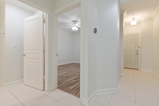 corridor with light tile patterned floors and baseboards