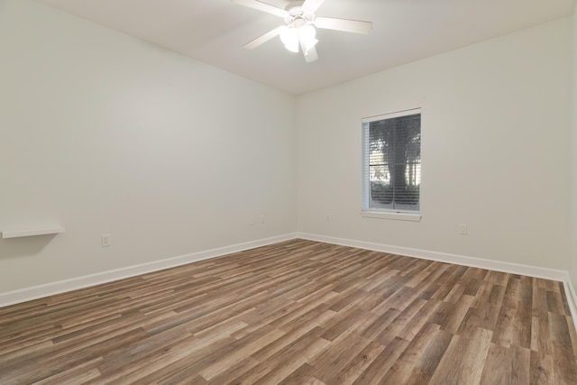 empty room with baseboards, wood finished floors, and a ceiling fan
