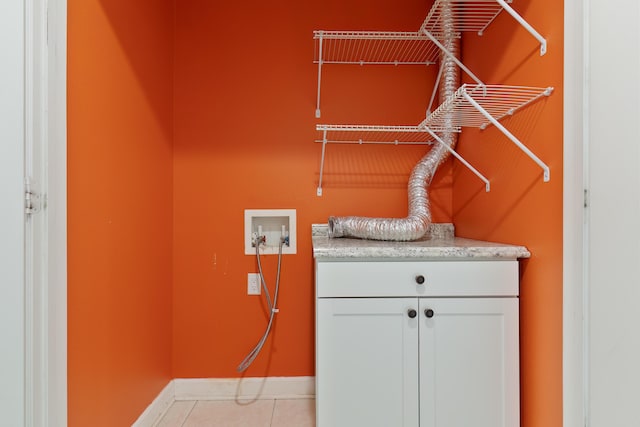 clothes washing area featuring tile patterned floors, cabinet space, hookup for a washing machine, and baseboards