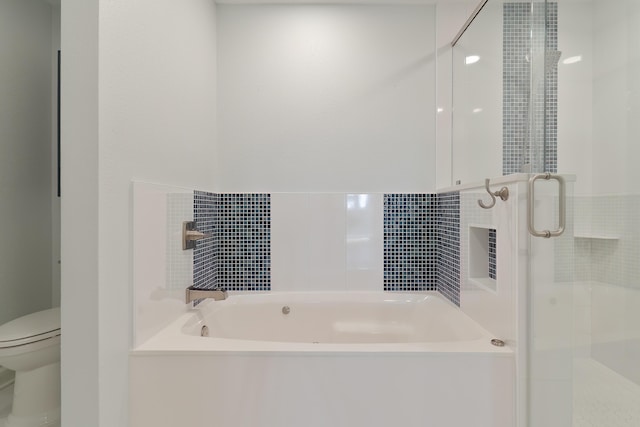 bathroom with toilet, a stall shower, and a garden tub