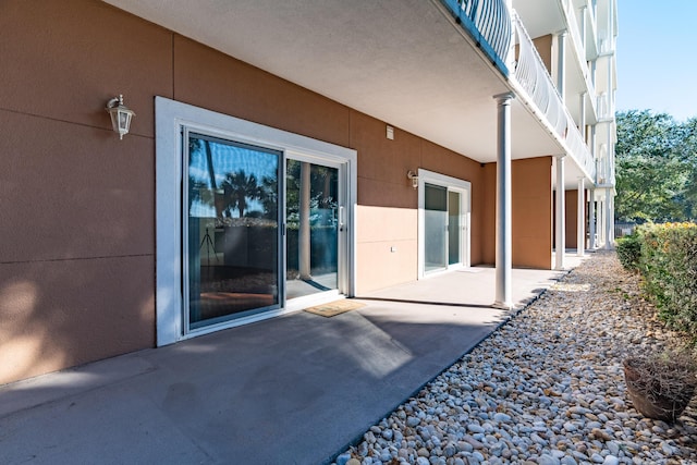 exterior space with stucco siding and a patio