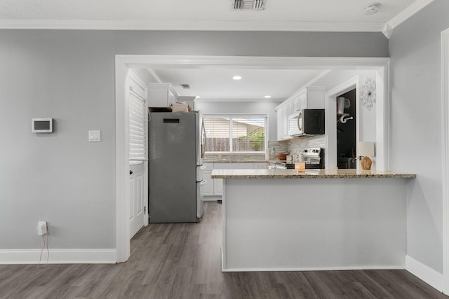 kitchen featuring white cabinets, stainless steel appliances, light stone counters, and dark wood-type flooring