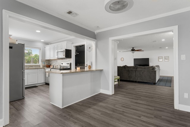 kitchen with ceiling fan, dark wood-type flooring, stainless steel appliances, kitchen peninsula, and white cabinets