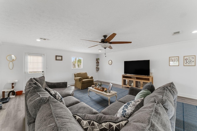 living room with crown molding, ceiling fan, a textured ceiling, and hardwood / wood-style flooring