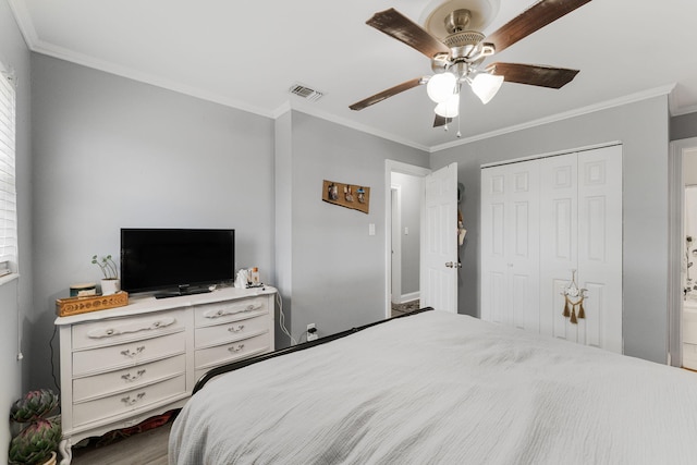 bedroom featuring ceiling fan, ornamental molding, and a closet