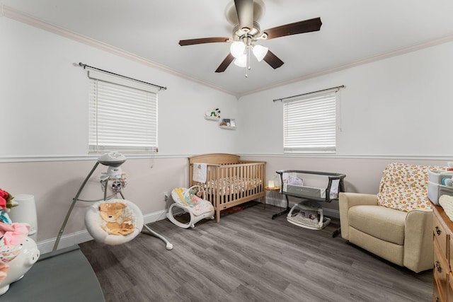 bedroom featuring hardwood / wood-style flooring, ceiling fan, a crib, and ornamental molding