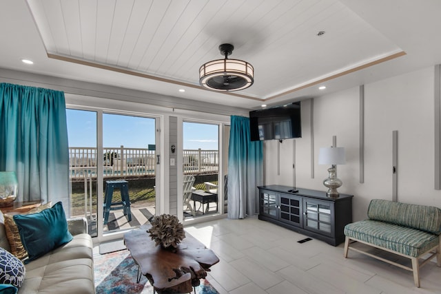 living area featuring a tray ceiling, wooden ceiling, and recessed lighting