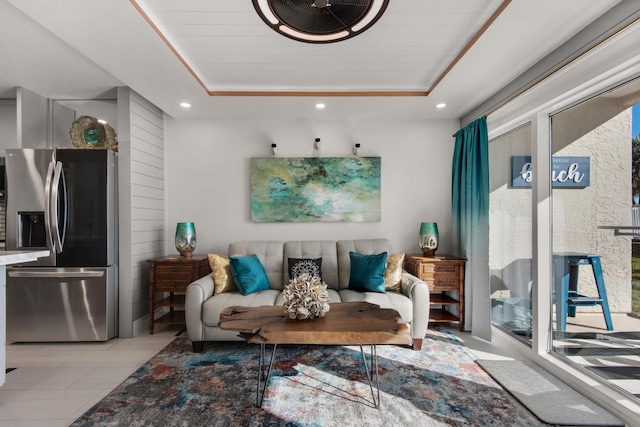 living room with a tray ceiling, a healthy amount of sunlight, and recessed lighting