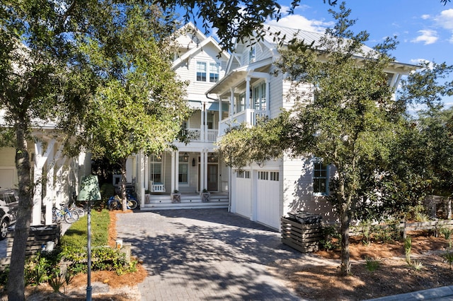 view of front of property featuring a porch, a balcony, and a garage