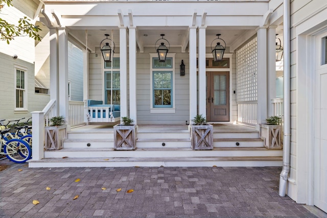 view of exterior entry featuring covered porch