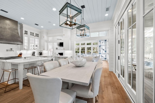 dining space featuring wood ceiling, french doors, and light hardwood / wood-style flooring