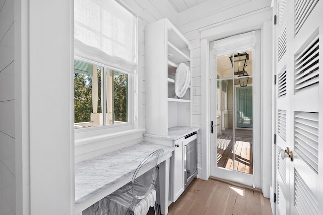 spacious closet with light hardwood / wood-style flooring and beverage cooler