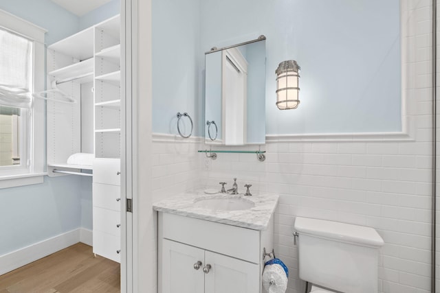 bathroom featuring hardwood / wood-style floors, vanity, and tile walls