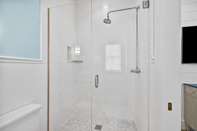 bathroom with a shower with door and toilet