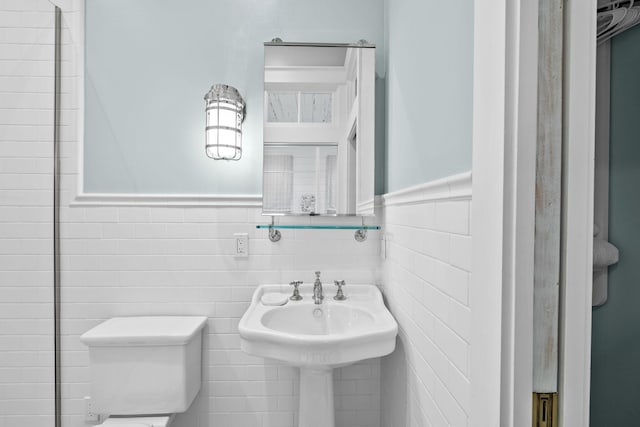 bathroom with tile walls and toilet