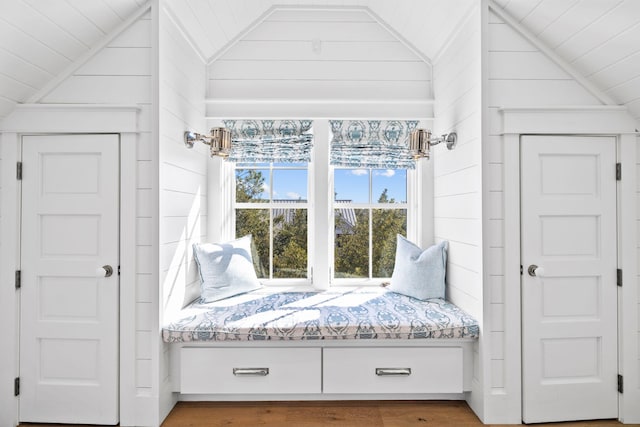 unfurnished room with lofted ceiling, wood walls, wood-type flooring, and wooden ceiling