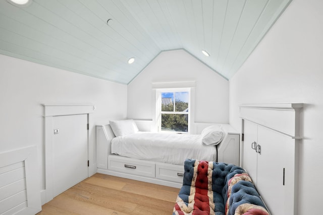 bedroom featuring light hardwood / wood-style floors, wood ceiling, and vaulted ceiling