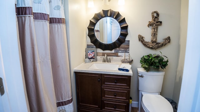 bathroom with walk in shower, vanity, and toilet