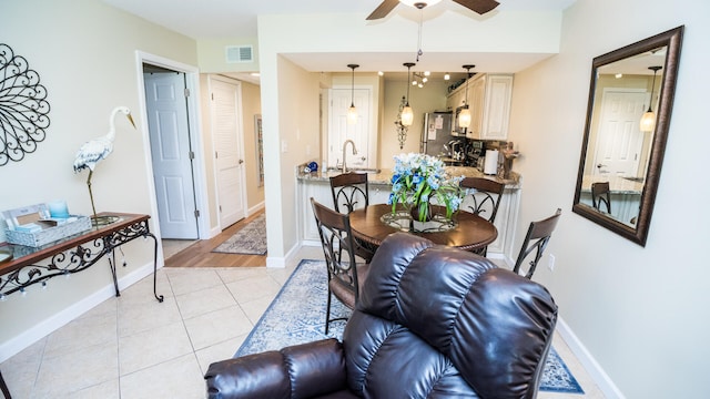 dining area with ceiling fan, sink, and light tile patterned flooring