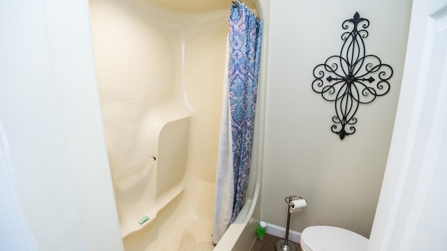 bathroom featuring curtained shower, hardwood / wood-style flooring, and toilet