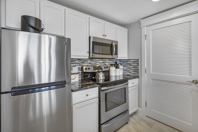 kitchen with white cabinets, decorative backsplash, and stainless steel appliances