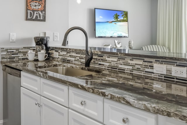 kitchen with white cabinetry, sink, tasteful backsplash, stainless steel dishwasher, and dark stone countertops