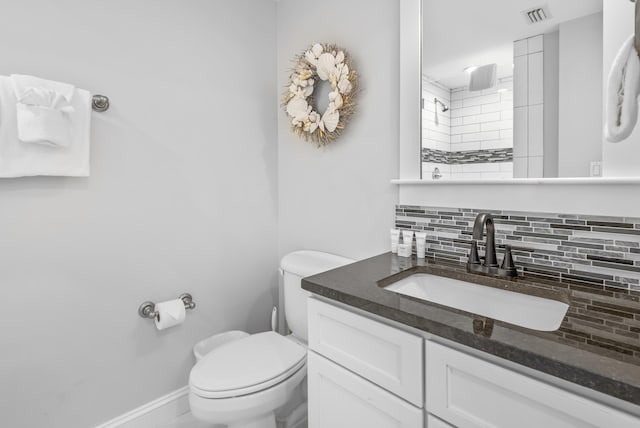 bathroom featuring tasteful backsplash, vanity, walk in shower, and toilet