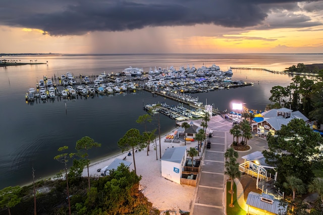 aerial view at dusk featuring a water view