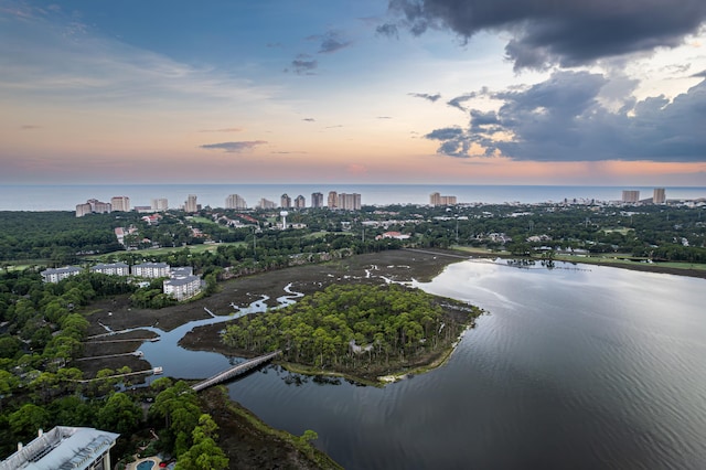 aerial view at dusk featuring a water view