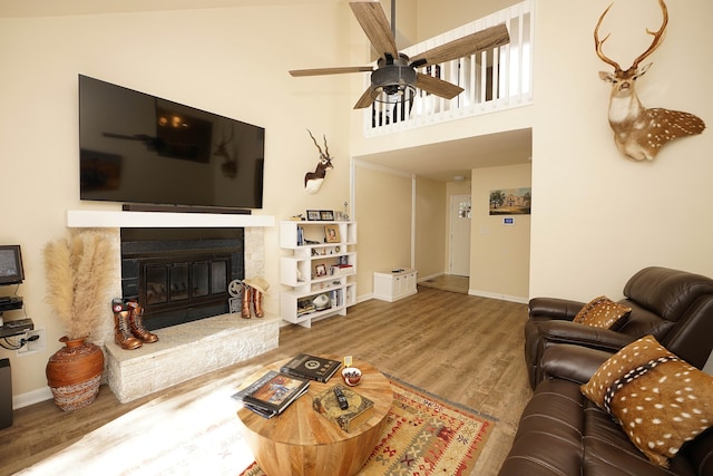 living room with wood-type flooring, a towering ceiling, and ceiling fan